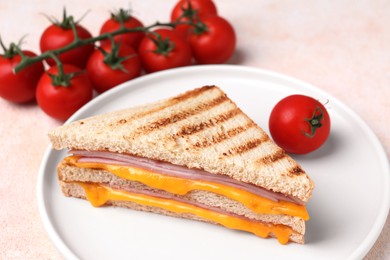 Photo of Delicious grilled sandwich with ham, cheese and tomatoes on light table, closeup