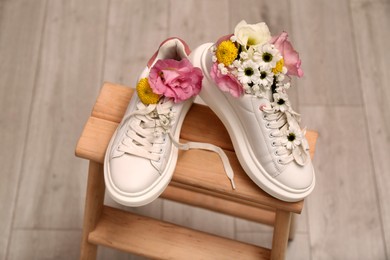 Shoes with beautiful flowers on wooden stand