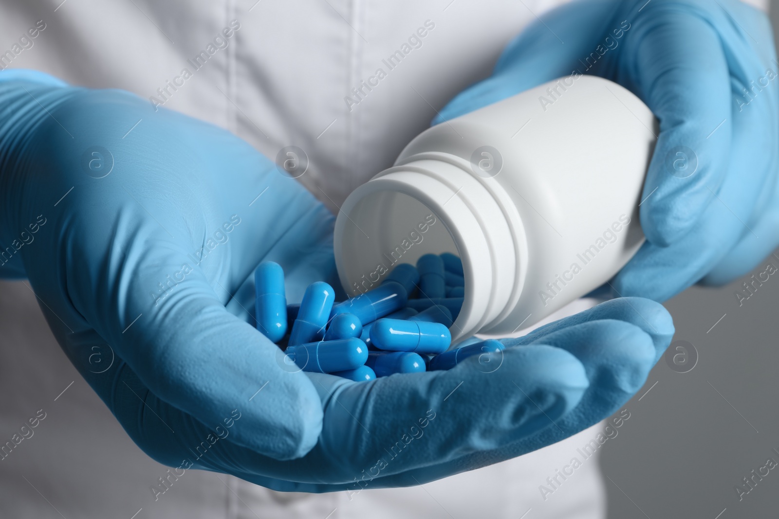 Photo of Doctor pouring pills from bottle onto hand, closeup view