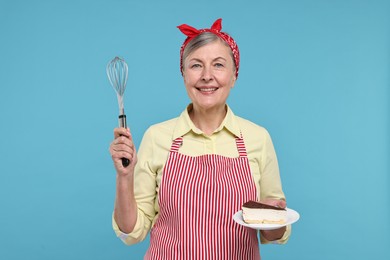 Photo of Happy housewife with whisk and piece of cake on light blue background