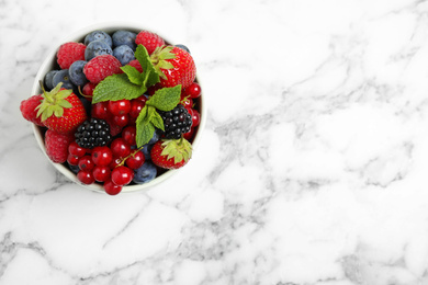 Photo of Mix of ripe berries on white marble table, top view. Space for text