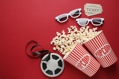 Photo of Flat lay composition with delicious popcorn on red background