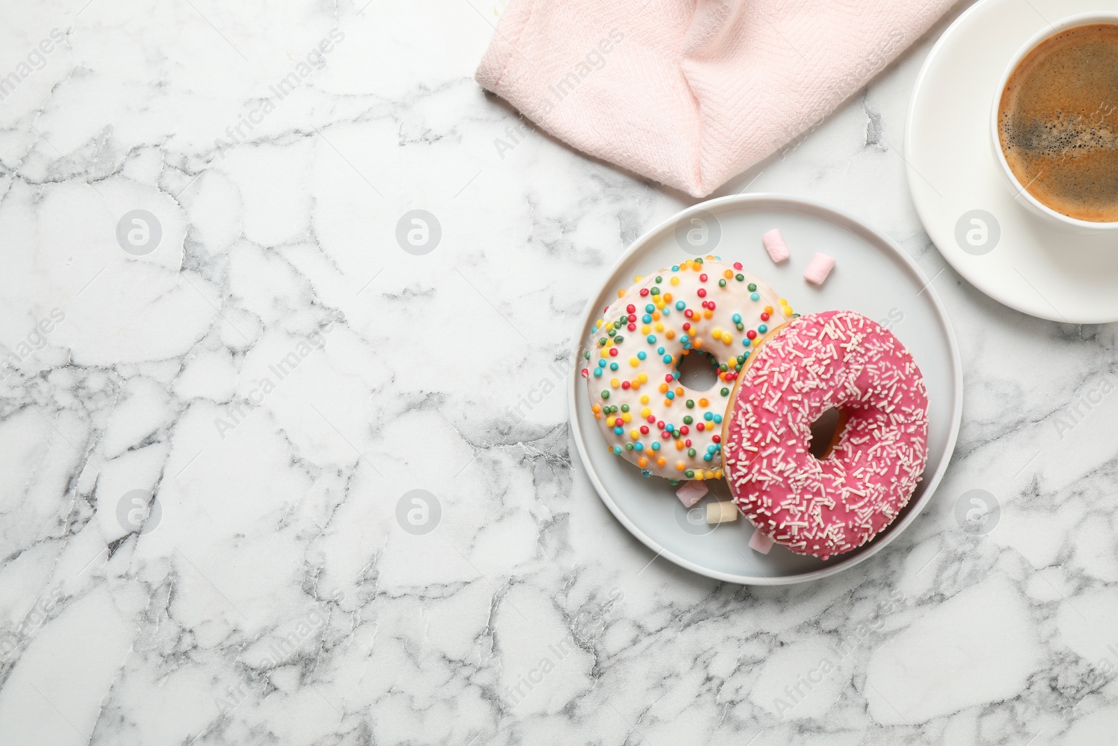 Photo of Yummy donuts with sprinkles and coffee on white marble table, flat lay. Space for text