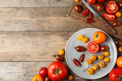 Flat lay composition with fresh ripe tomatoes on wooden table. Space for text