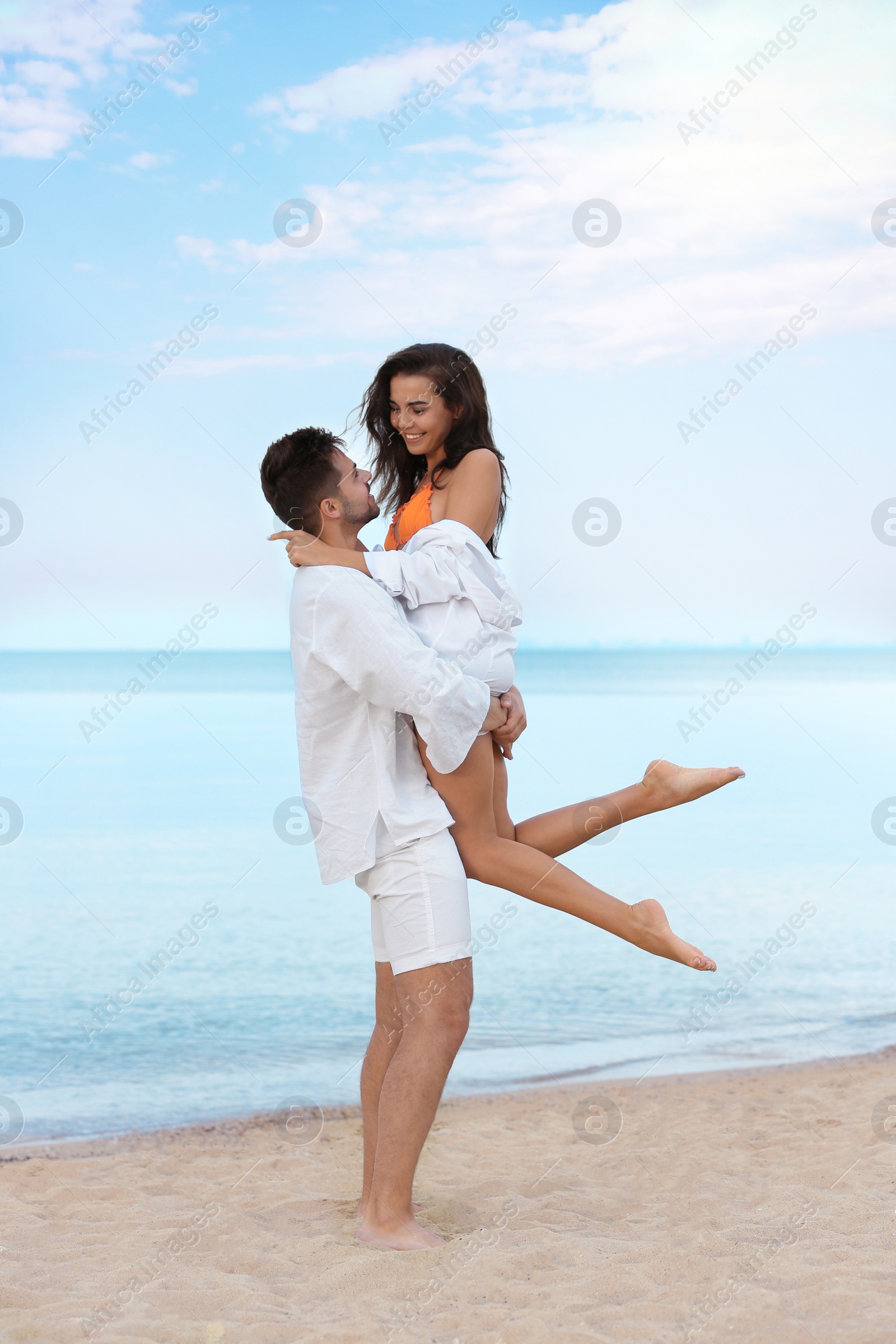 Photo of Happy young couple spending time together on beach near sea