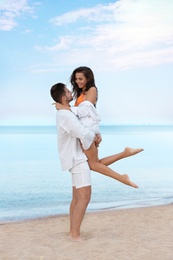 Photo of Happy young couple spending time together on beach near sea