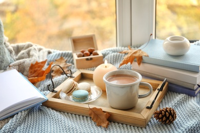 Photo of Tray with breakfast near stack of books on windowsill