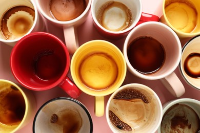 Photo of Many dirty cups after drinking coffee on pink table, flat lay