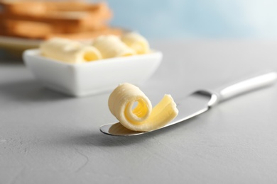 Knife with fresh butter curl on table