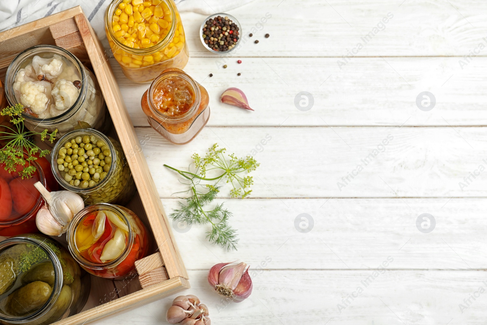 Photo of Jars with pickled vegetables on white wooden table, flat lay. Space for text