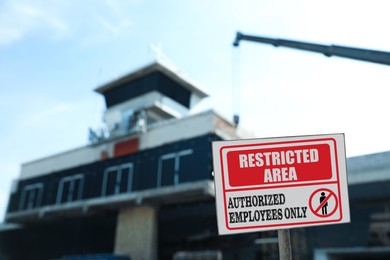 Sign with text Restricted Area Authorized Employees Only near unfinished building outdoors