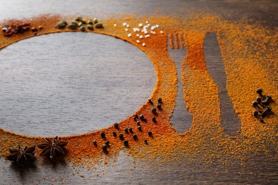 Silhouettes of cutlery and plate made with spices on wooden table, space for text