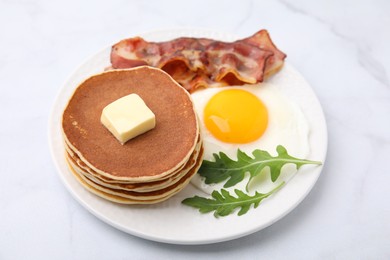 Tasty pancakes with fried egg and bacon on white table