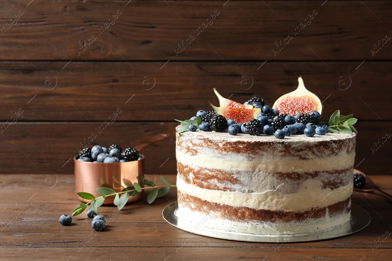 Photo of Delicious homemade cake with fresh berries served on wooden table. Space for text