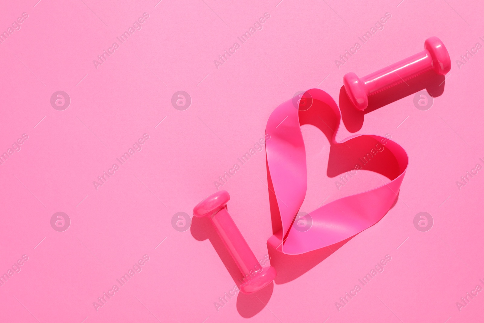 Photo of Dumbbells and fitness elastic band on pink background, flat lay. Space for text