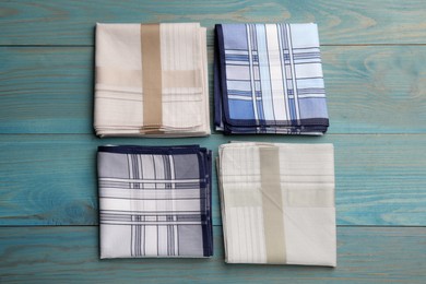 Photo of Stylish handkerchiefs on light blue wooden table, flat lay