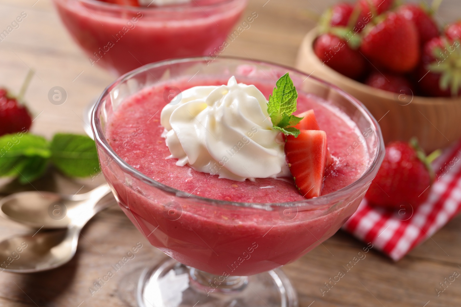 Photo of Delicious strawberry mousse with mint on wooden table