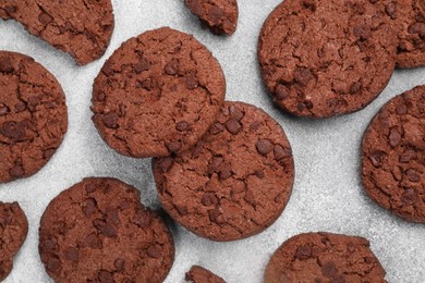 Photo of Tasty chocolate cookies on light grey textured table, flat lay