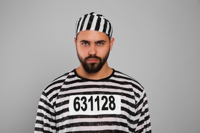 Prisoner in special uniform on grey background