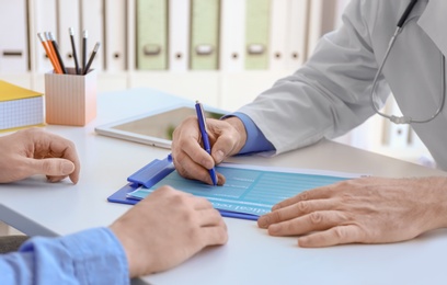 Photo of Mature doctor consulting patient in clinic, closeup