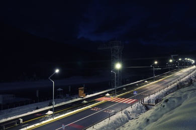 Lit road with snow on sides in evening