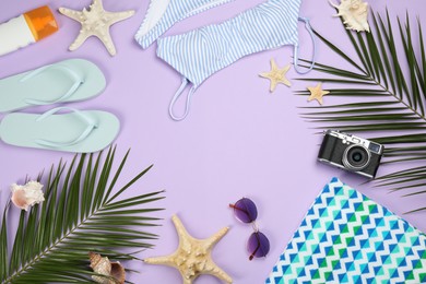 Frame of beach objects on violet background, flat lay. Space for text