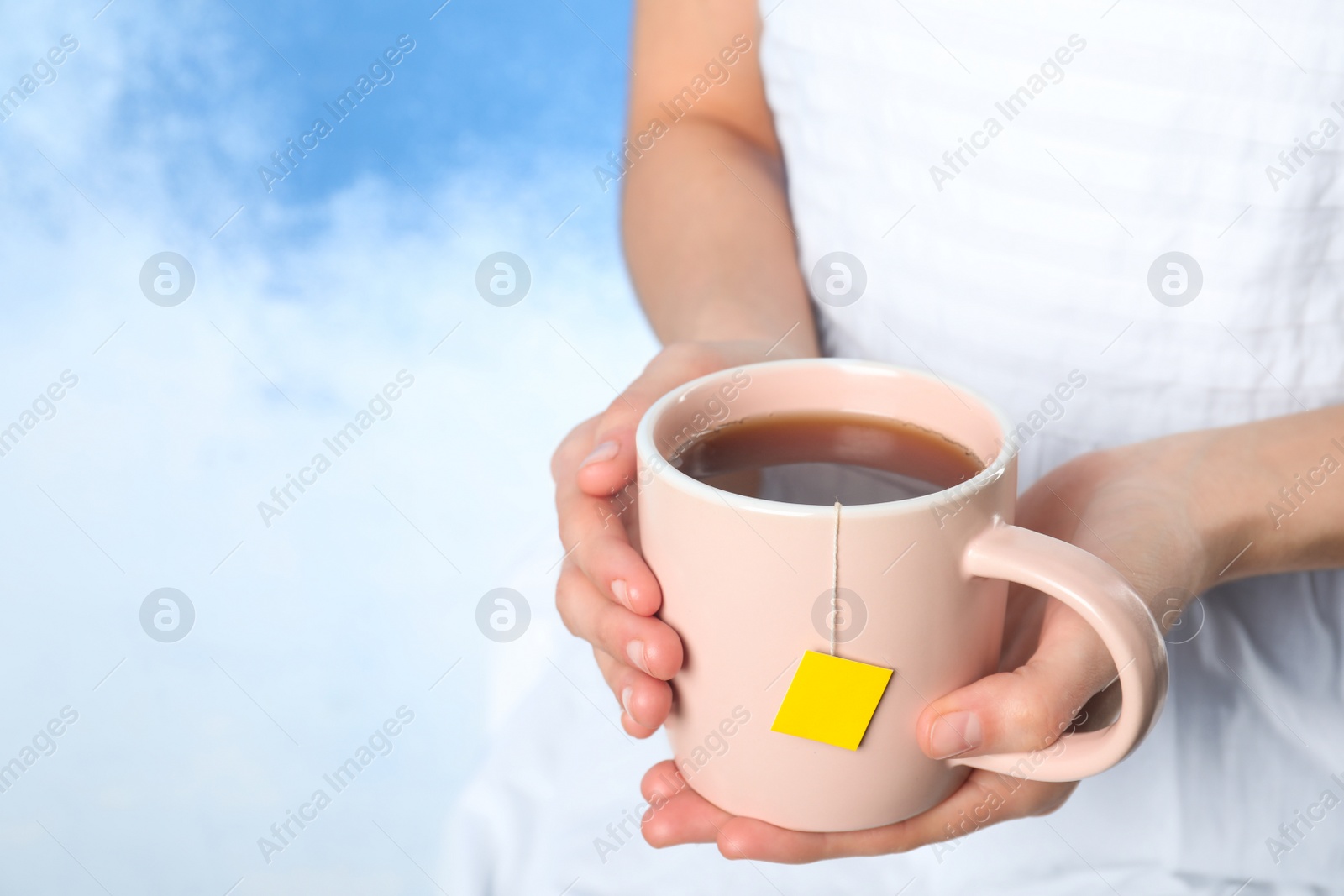 Photo of Woman with cup of hot tea, closeup. Space for text