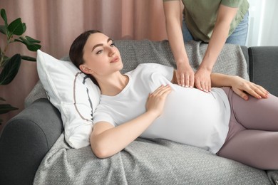 Doula taking care of pregnant woman at home. Preparation for child birth