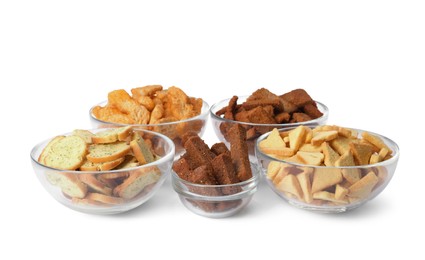 Photo of Different crispy rusks in bowls on white background