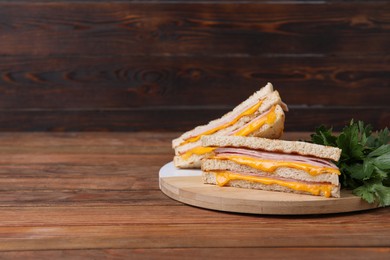 Photo of Delicious grilled sandwiches with ham, cheese and parsley on wooden table. Space for text