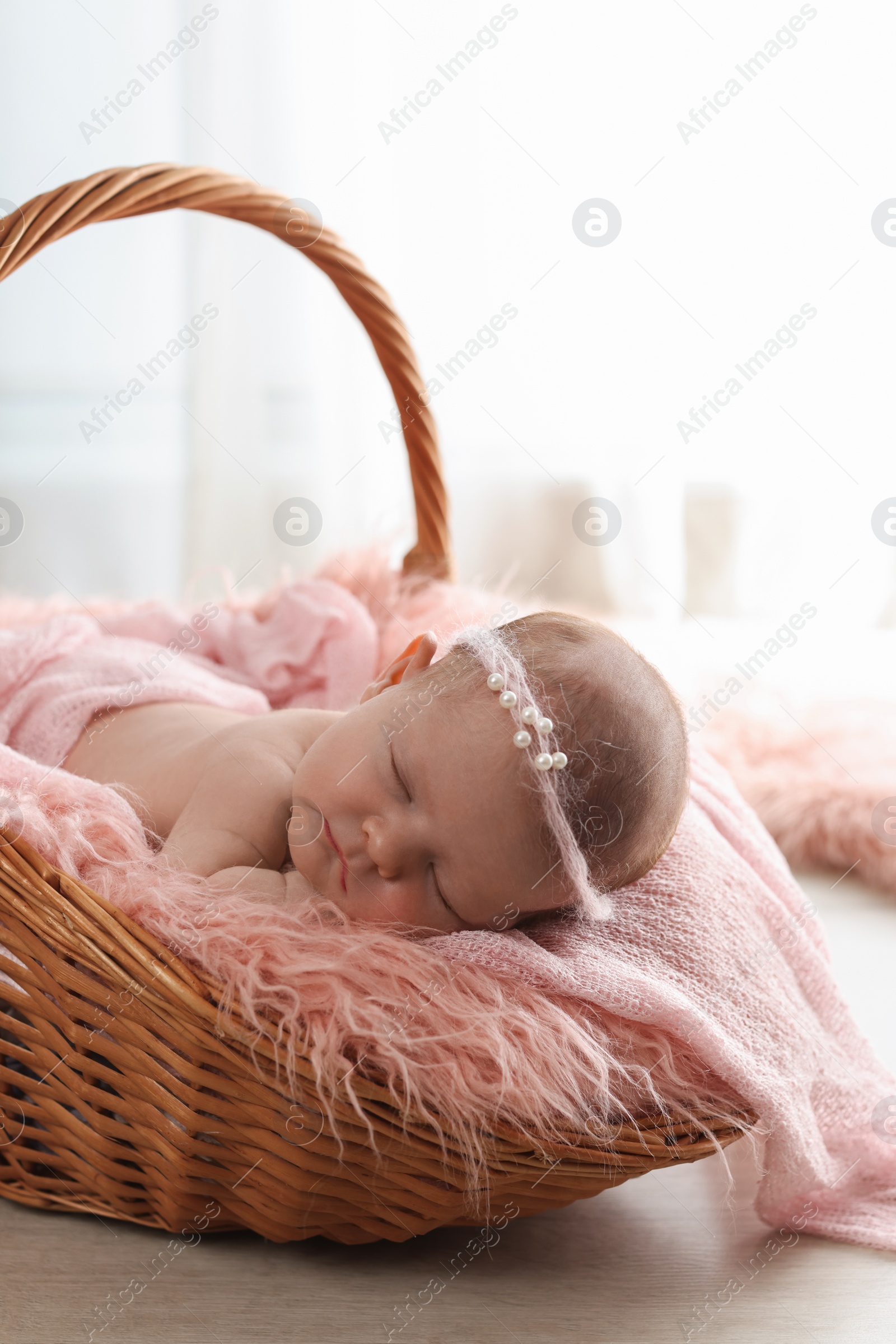 Photo of Adorable little baby sleeping in wicker basket at home