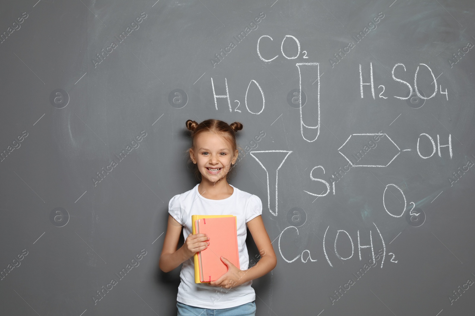 Photo of Little child with school supplies and chemical formulas on grey background