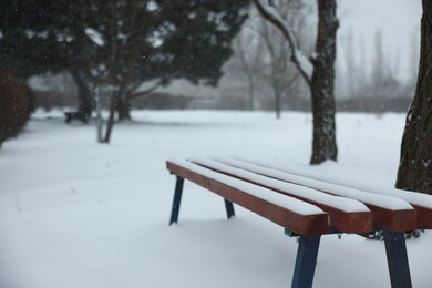 Bench covered with snow in city park