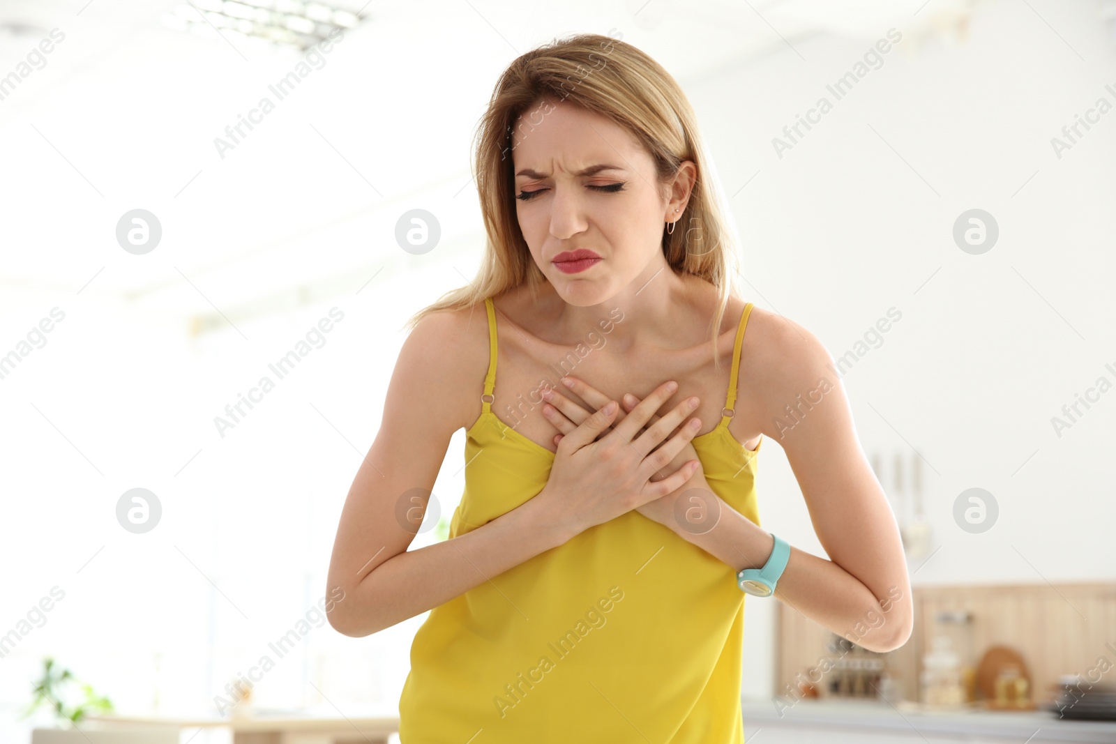 Photo of Young woman having heart attack indoors