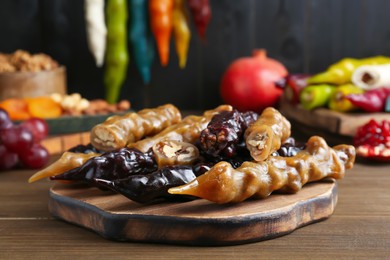 Photo of Many delicious sweet churchkhelas on wooden table
