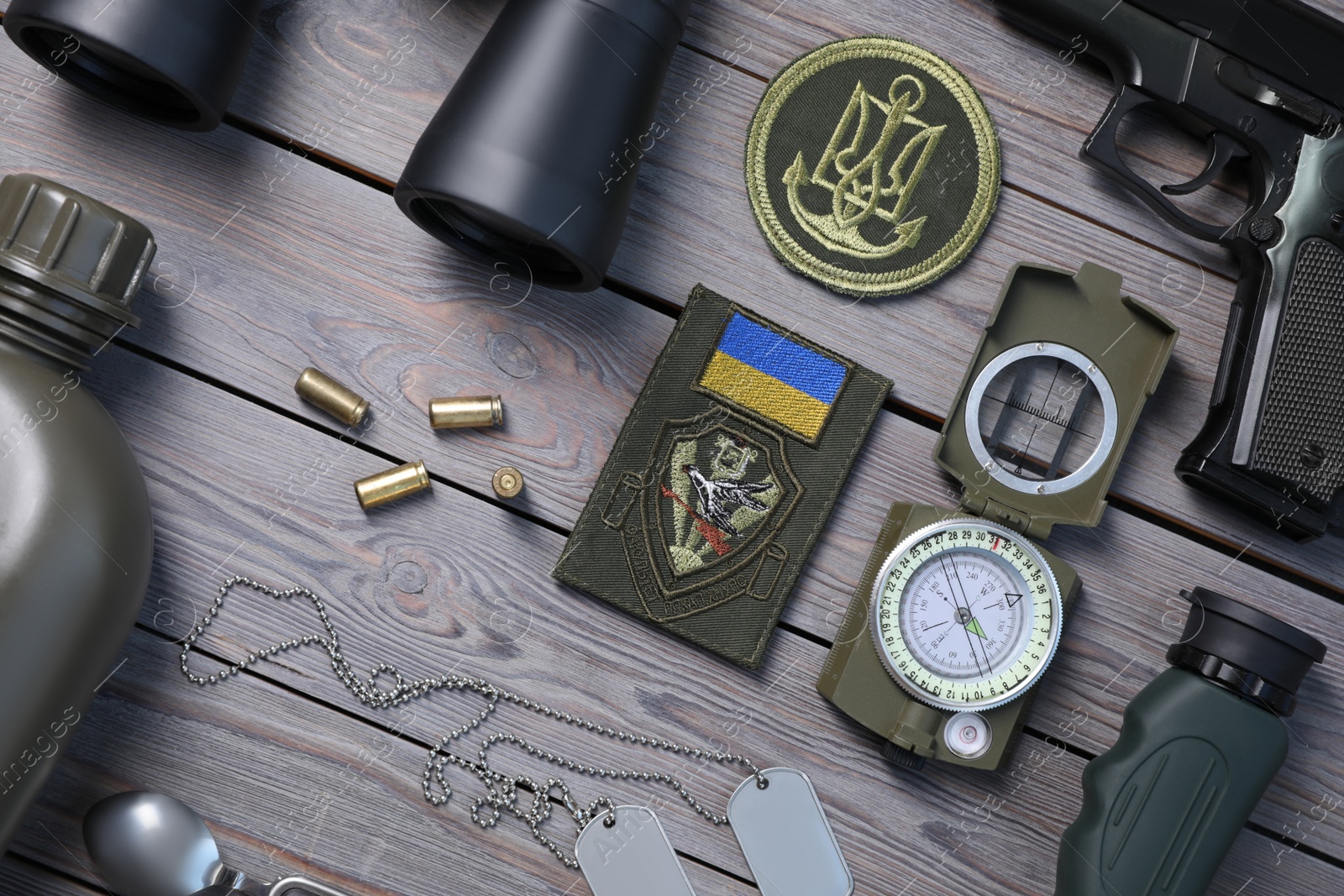 Photo of MYKOLAIV, UKRAINE - SEPTEMBER 19, 2020: Flat lay composition with Ukraine military equipment on grey wooden table