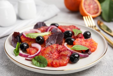 Photo of Plate of delicious sicilian orange salad on grey table, closeup