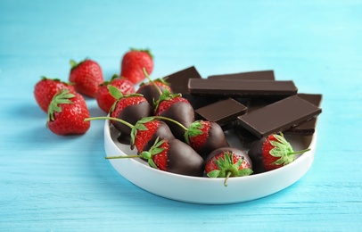 Photo of Plate with chocolate covered strawberries on wooden table