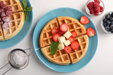 Photo of Tasty Belgian waffles with fresh berries served on white table, flat lay