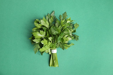 Photo of Bunch of fresh green parsley on color background, view from above