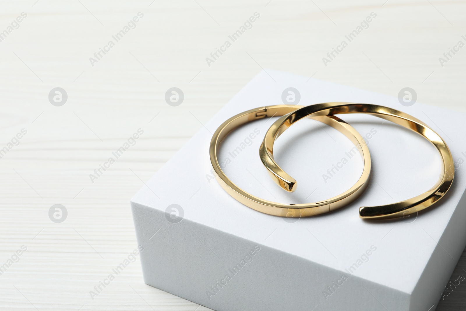 Photo of Stylish presentation of bracelets on podium, space for text