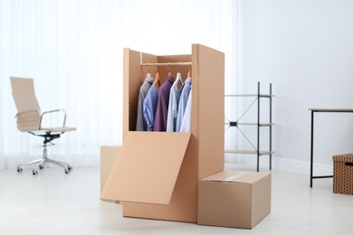 Photo of Wardrobe box with clothes in room interior
