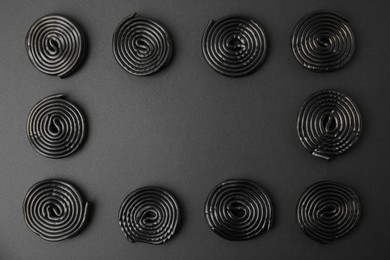 Photo of Tasty liquorice candies on black background, flat lay. Space for text