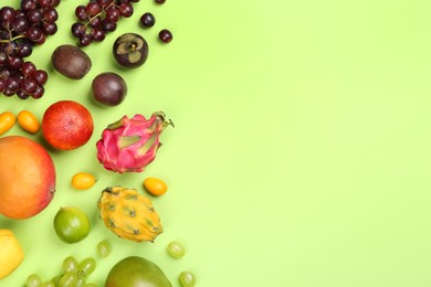 Photo of Many different delicious exotic fruits on green background, flat lay. Space for text