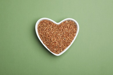 Buckwheat grains on green background, top view