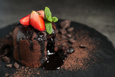 Photo of Delicious warm chocolate lava cake on slate board, closeup. Space for text