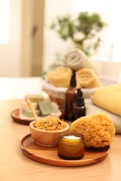 Photo of Dry flowers, loofah and jar with cream on wooden table indoors, space for text. Spa time