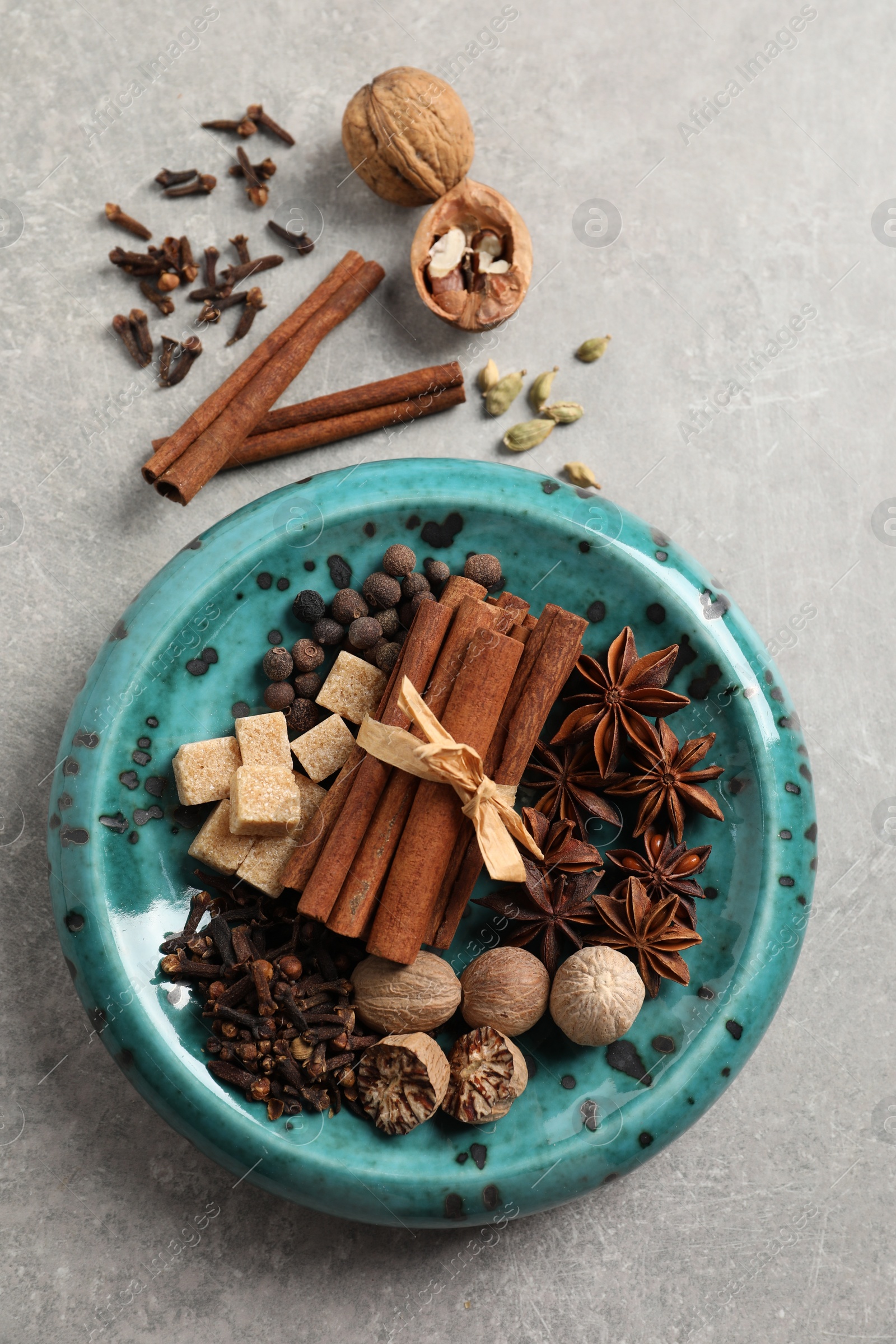 Photo of Different aromatic spices on light textured table, flat lay