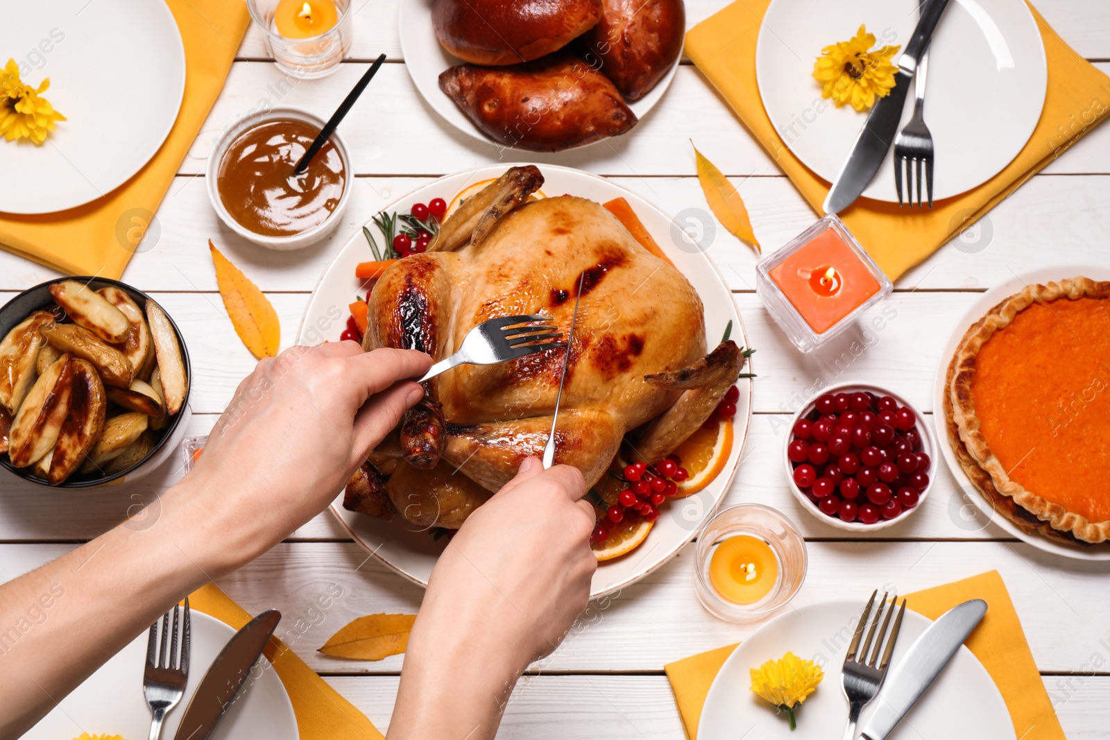 Photo of Woman eating traditional cooked turkey at white wooden table, top view. Thanksgiving day celebration