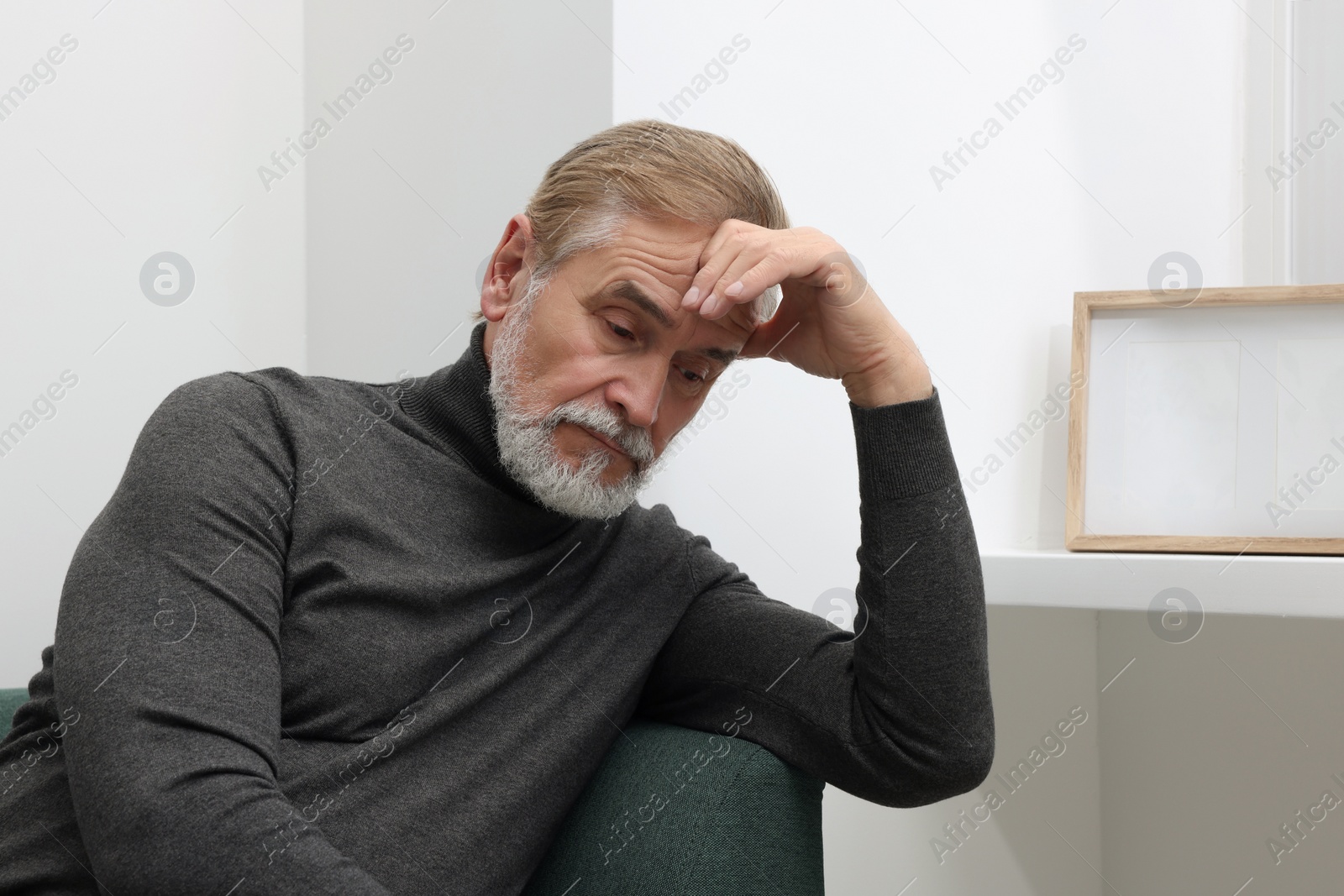 Photo of Upset senior man on sofa at home. Loneliness concept